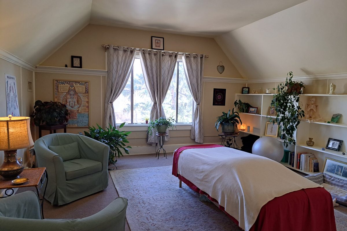 The treatment room with armchairs, plants and the massage table